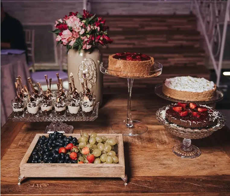 Mesa de sobremesas finas com tortas, verrines e frutas